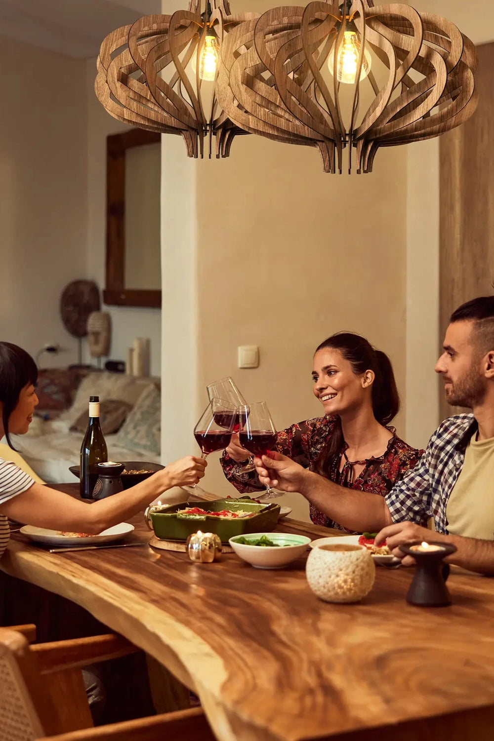 friends having dinner below beautiful pendant lights